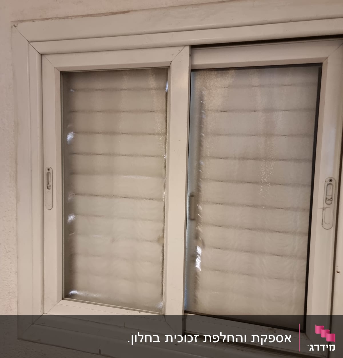 חלון זכוכית עם מסגרת לבנה ותריסים סגורים